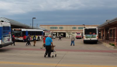 People walking between buses at the Transit Center